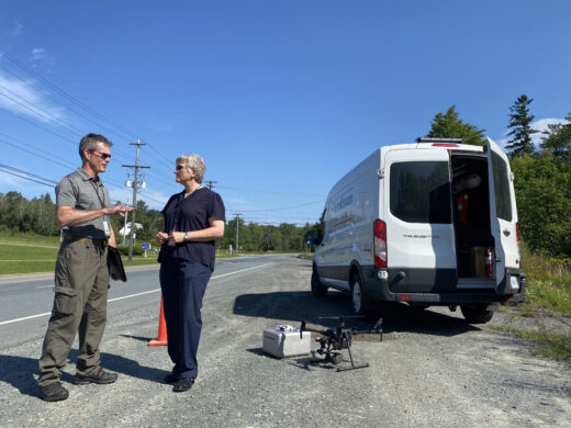 Investigations Director Barbara MacLean briefs team member during a community site visit for drone work - August 25, 2021